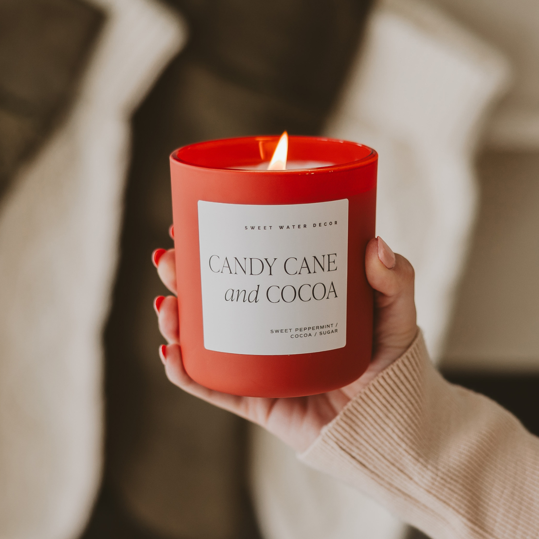 Woman holding Candy Cane and Cocoa candle in red matte glass container. Sweet Peppermint / Cocoa / Sugar