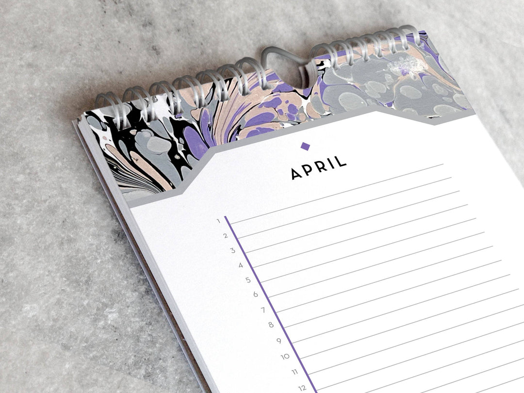 Page for April with marbled paper in shades of gray and lavender at the top and bottom. Below the month title is a line for each day of the month.