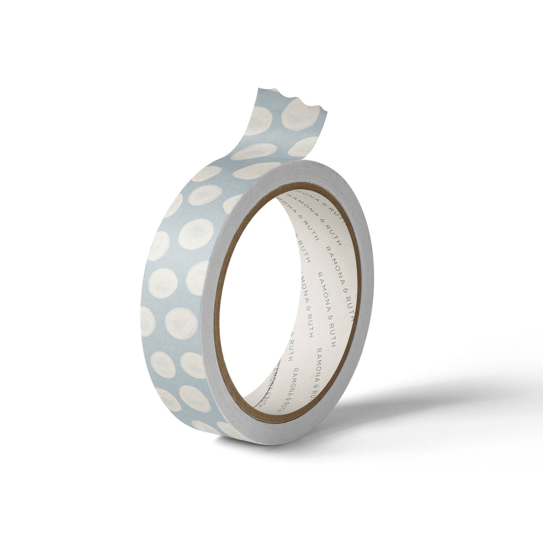 White dots on a roll of light blue washi tape.