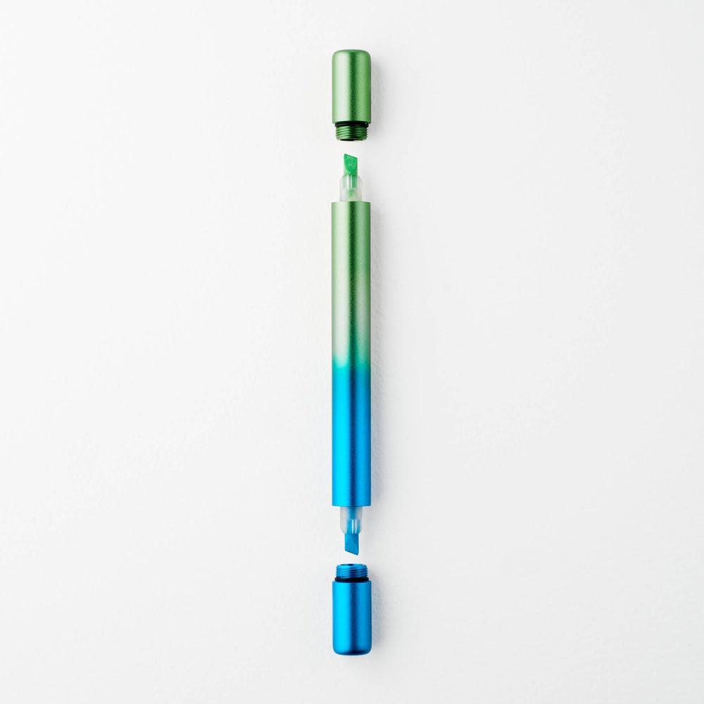 Gradient blue to green pen with caps off at either end showing a green tip at top and a blue tip at the bottom.