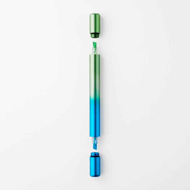 Gradient blue to green pen with caps off at either end showing a green tip at top and a blue tip at the bottom.