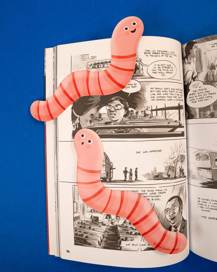 The front and back of a bookmark in the shape of a cartoonish pink worm-like character on a page in a book. The worms are identical except for the shape of their mouth.