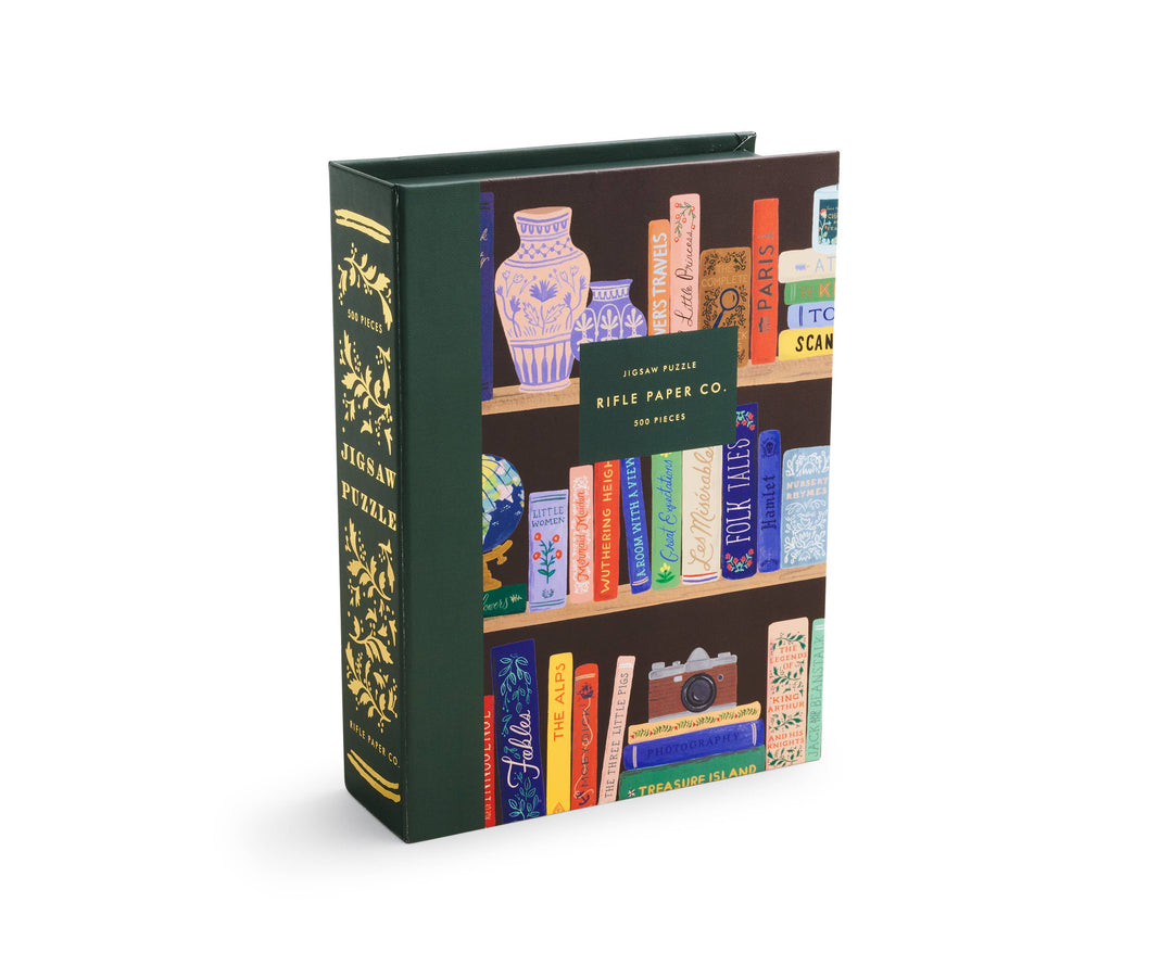 Puzzle box designed to look like a book, with an illustration of a bookshelf with books and a spine labeled "Jigsaw Puzzle."
