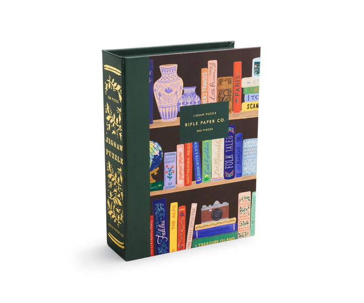 Puzzle box designed to look like a book, with an illustration of a bookshelf with books and a spine labeled "Jigsaw Puzzle."
