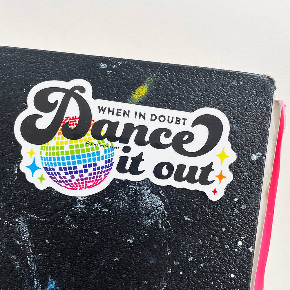 Text in black over a disco ball on a battered notebook.