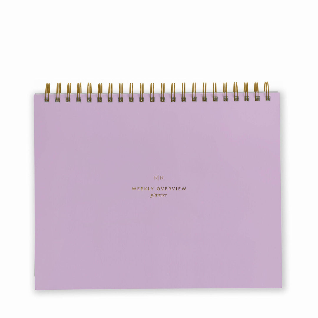 Cover of weekly planner in lavender with gold spiral binding at top.
