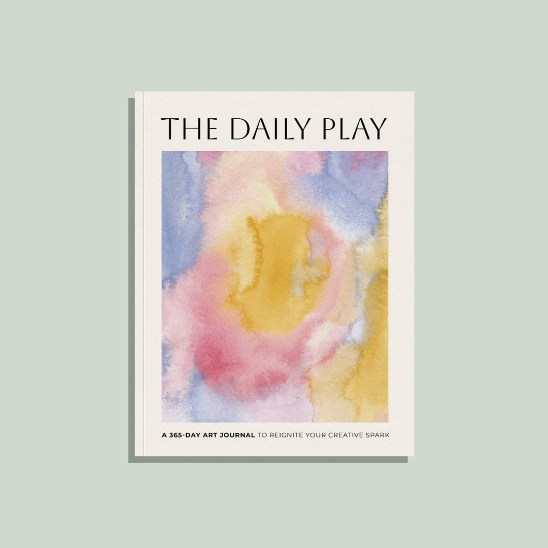Book titled 'The Daily Play' with a colorful abstract watercolor design on a light green background