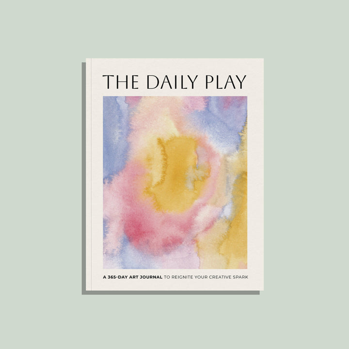 Book titled 'The Daily Play' with a colorful abstract watercolor design on a light green background