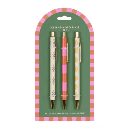 Three pens - one with a vertical row of small orange flowers, one with orange and pink horizontal stripes, and one with yellow dots - on green card with pink and orange border.