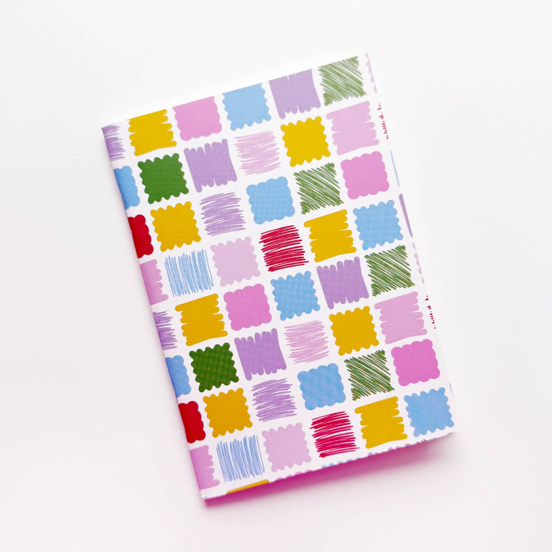 Notebook with colorful square pattern on a white background