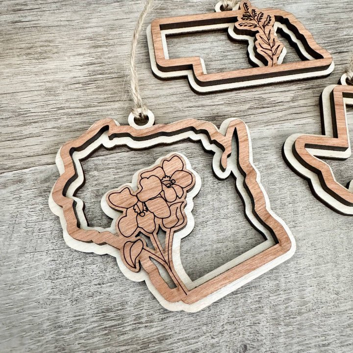 Cherry and birch wood finely hewn in the shape of Wisconsin, with the state flower the wood violet so hewn within its outline.