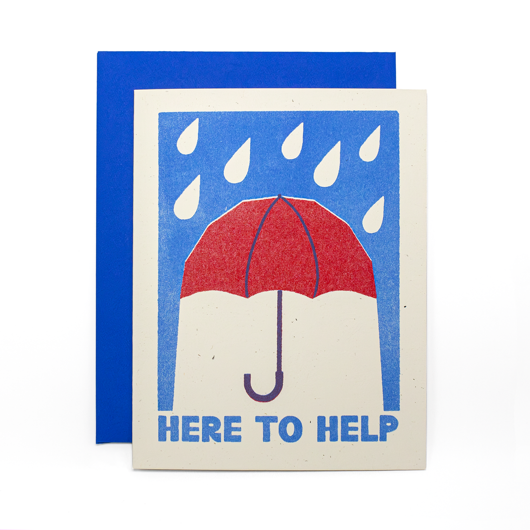 A greeting card with a blue envelope behind it, featuring a minimalist illustration of a red umbrella under falling raindrops on a cream background, with the text 'HERE TO HELP' in blue at the bottom.