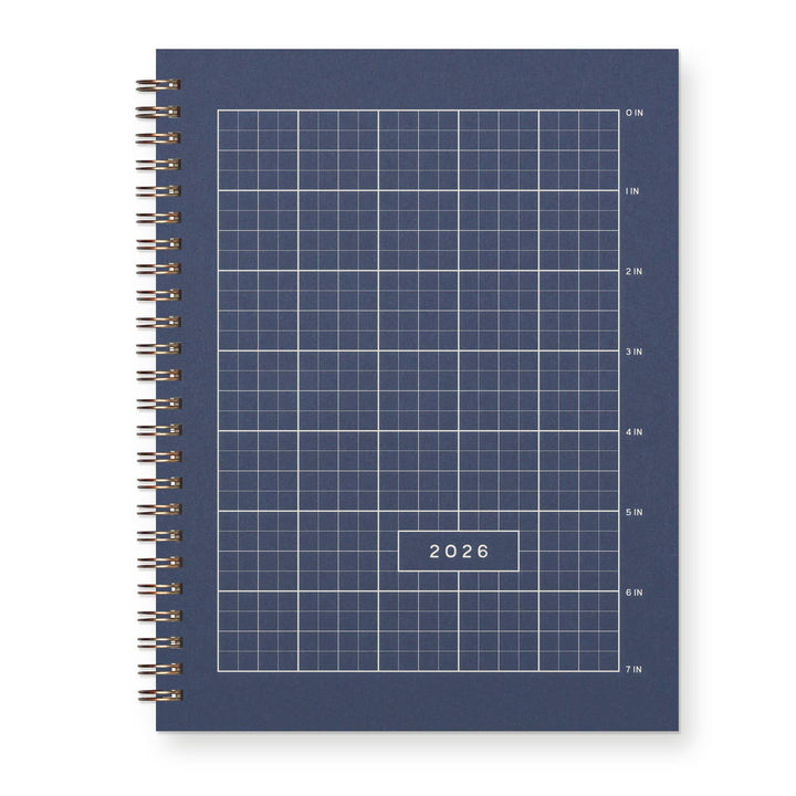 Cover of a deep blue spiral-bound planner with grid design and labeled '2026' with spiral Wire-O binding.