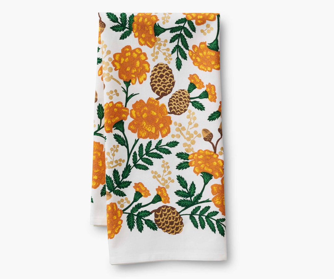 Folded tea towel with orange and brown floral pattern.