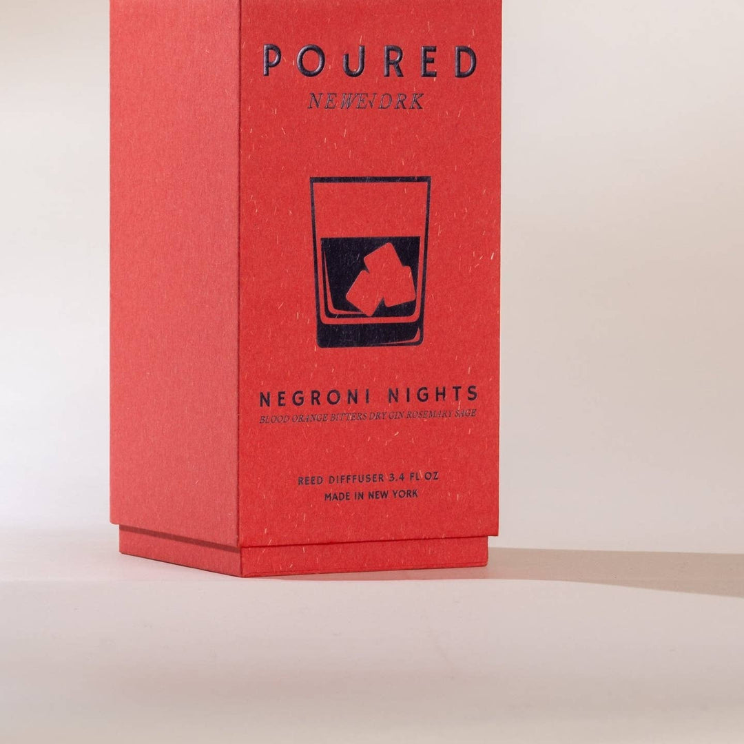 A red rectangular product box for a Poured New York reed diffuser labeled 'Negróni Nights.'