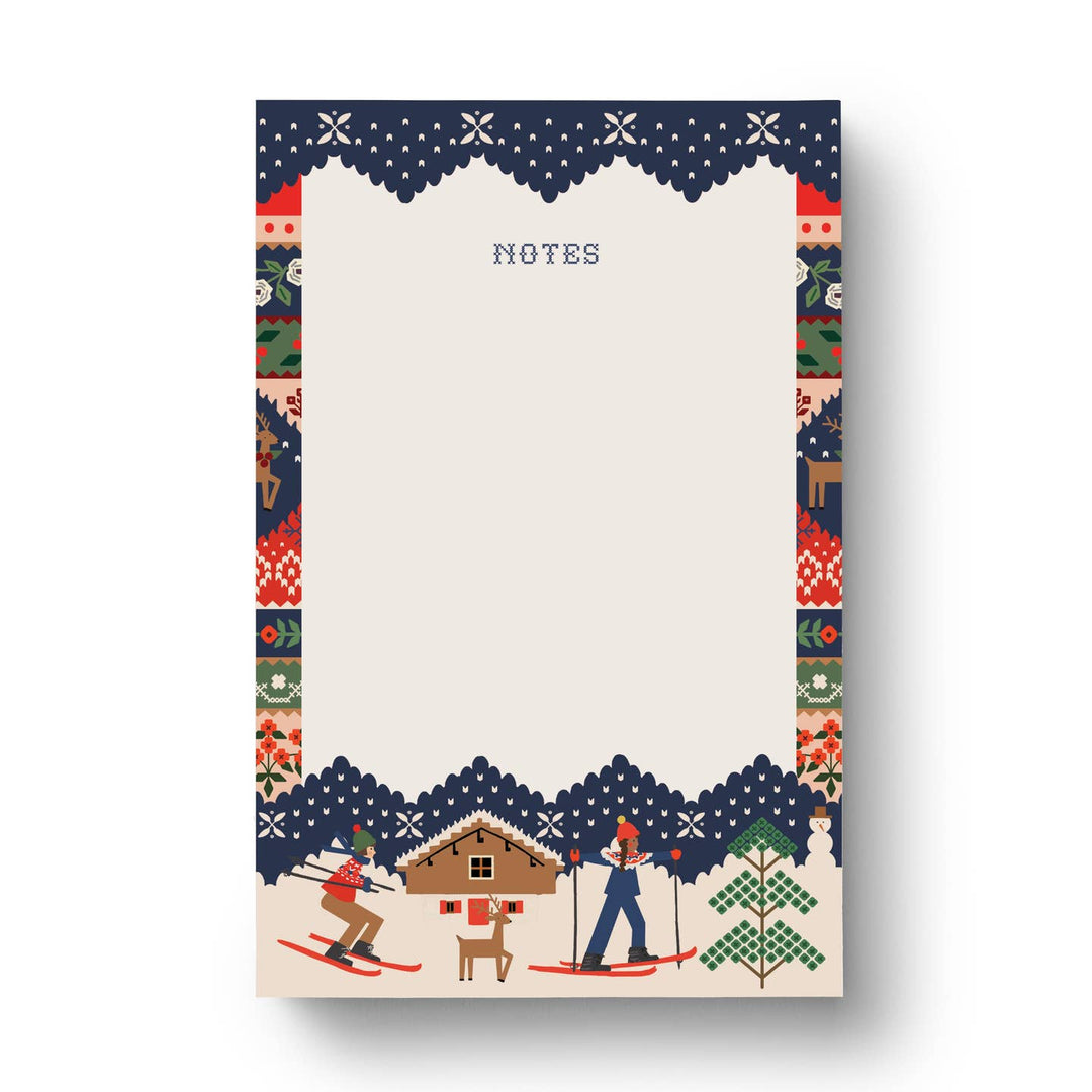 Notepad with winter-themed design around the edges featuring skiers and a cabin.