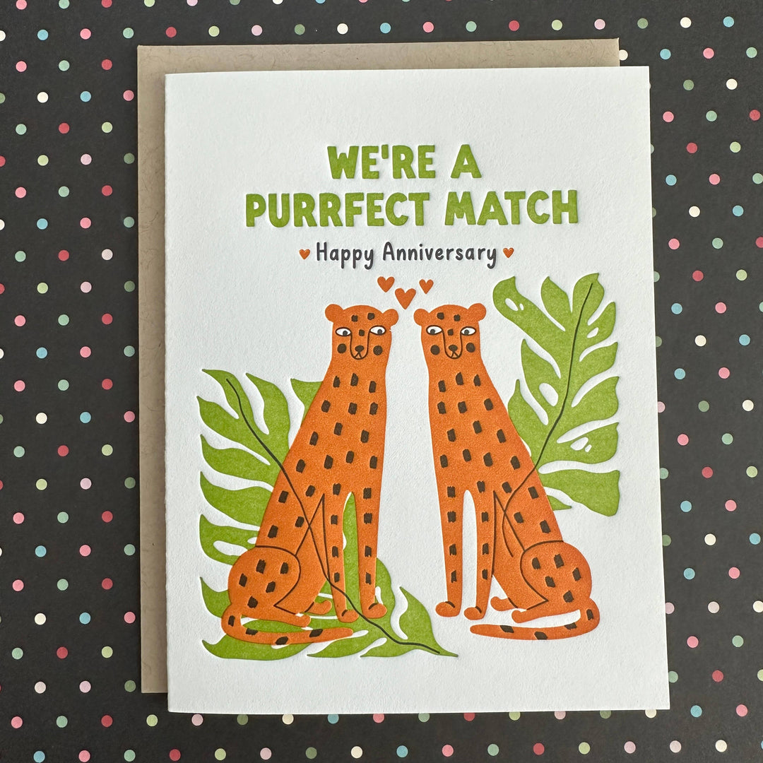 Drawing of two orange cheetahs with brown dots and large green leavers with green and black text on white cardstock