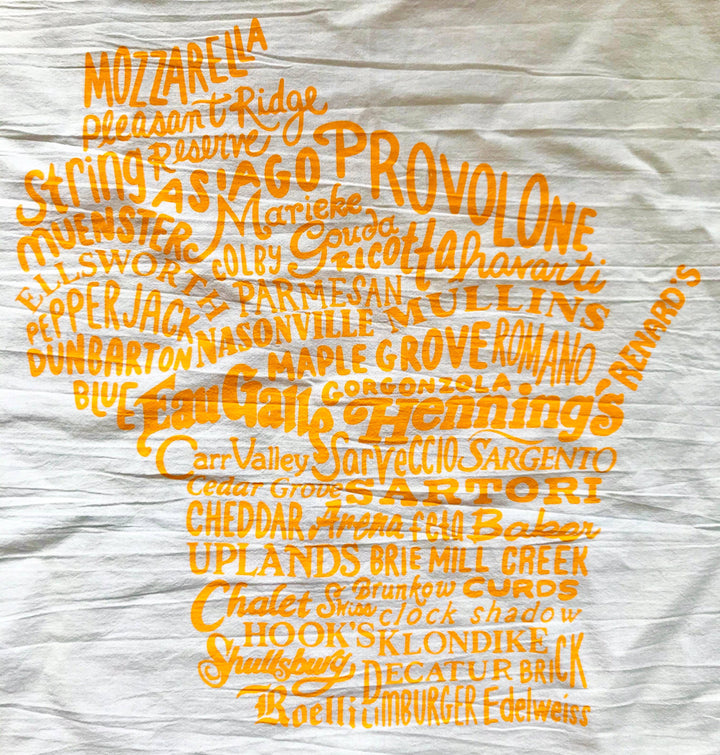 White cotton kitchen towel with the state of Wisconsin created from cheese names and local cheese makers in yellow using various typefaces.