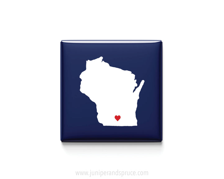 A square navy blue magnet featuring a white silhouette of the state of Wisconsin in white with a small red heart near the bottom center.
