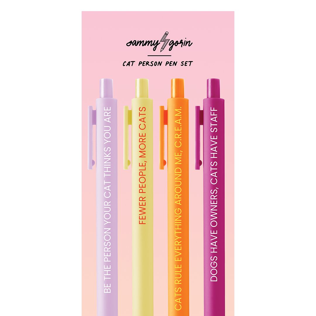 Four pens on a pink cardboard backing. The colors of the pens are: white text on lilac; orange text on yellow; yellow text on orange, and white text on cherry red.