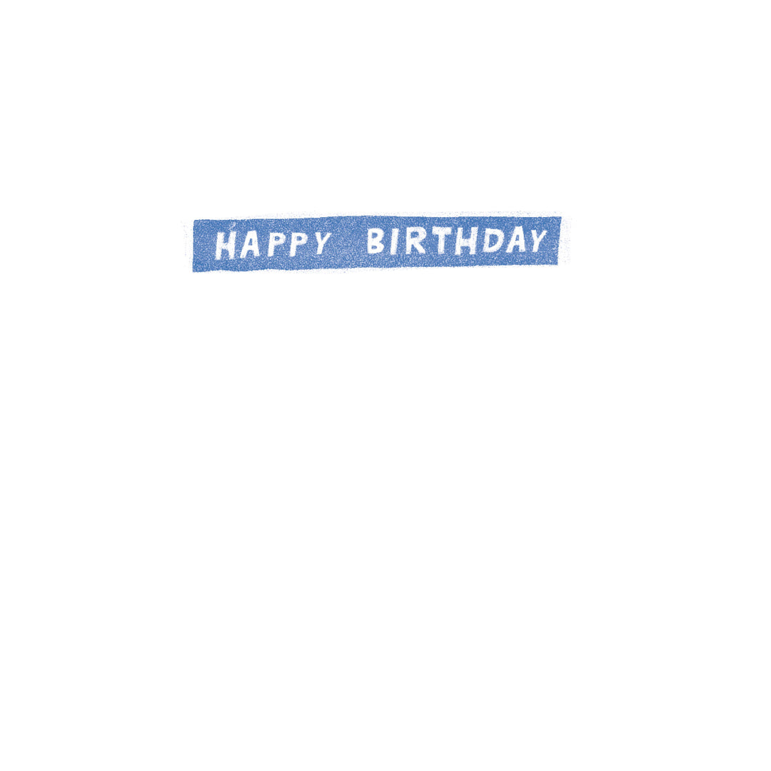 A rectangular blue sticker or label with the words 'HAPPY BIRTHDAY' in white capital letters