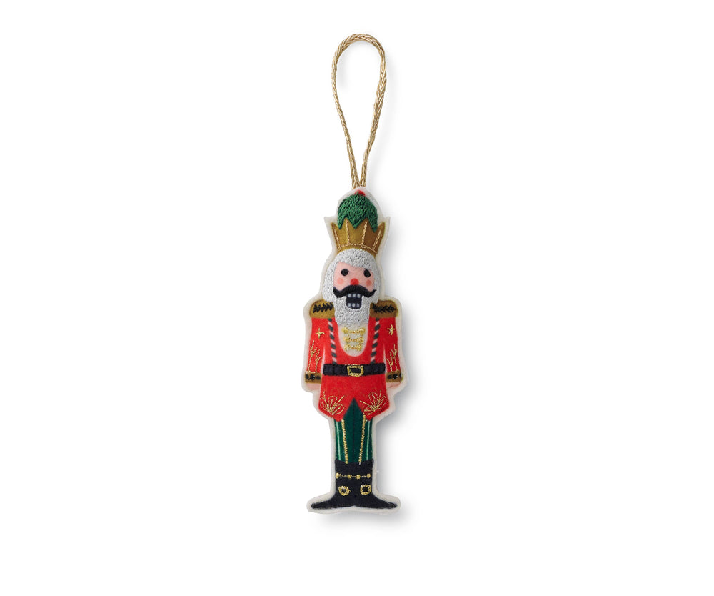 Nutcracker prince wearing a gold grown, red jacket, green pants, and black boots, with gold hanging string.