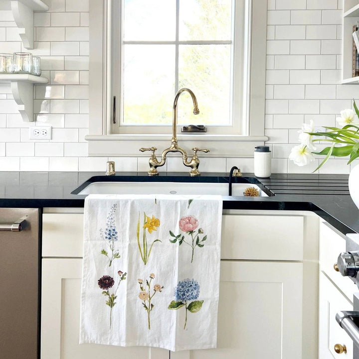 Kitchen towel draped over the front of a kitchen sink, with six of the flowers showing.