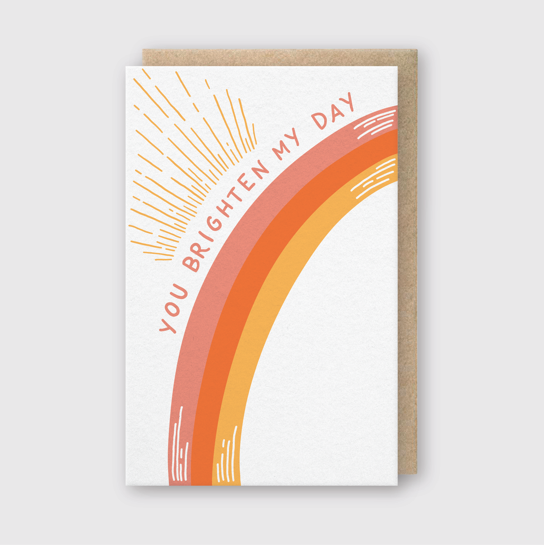 Cover of card with an arc in shades of orange and orange rays with the text 'You Brighten My Day.'