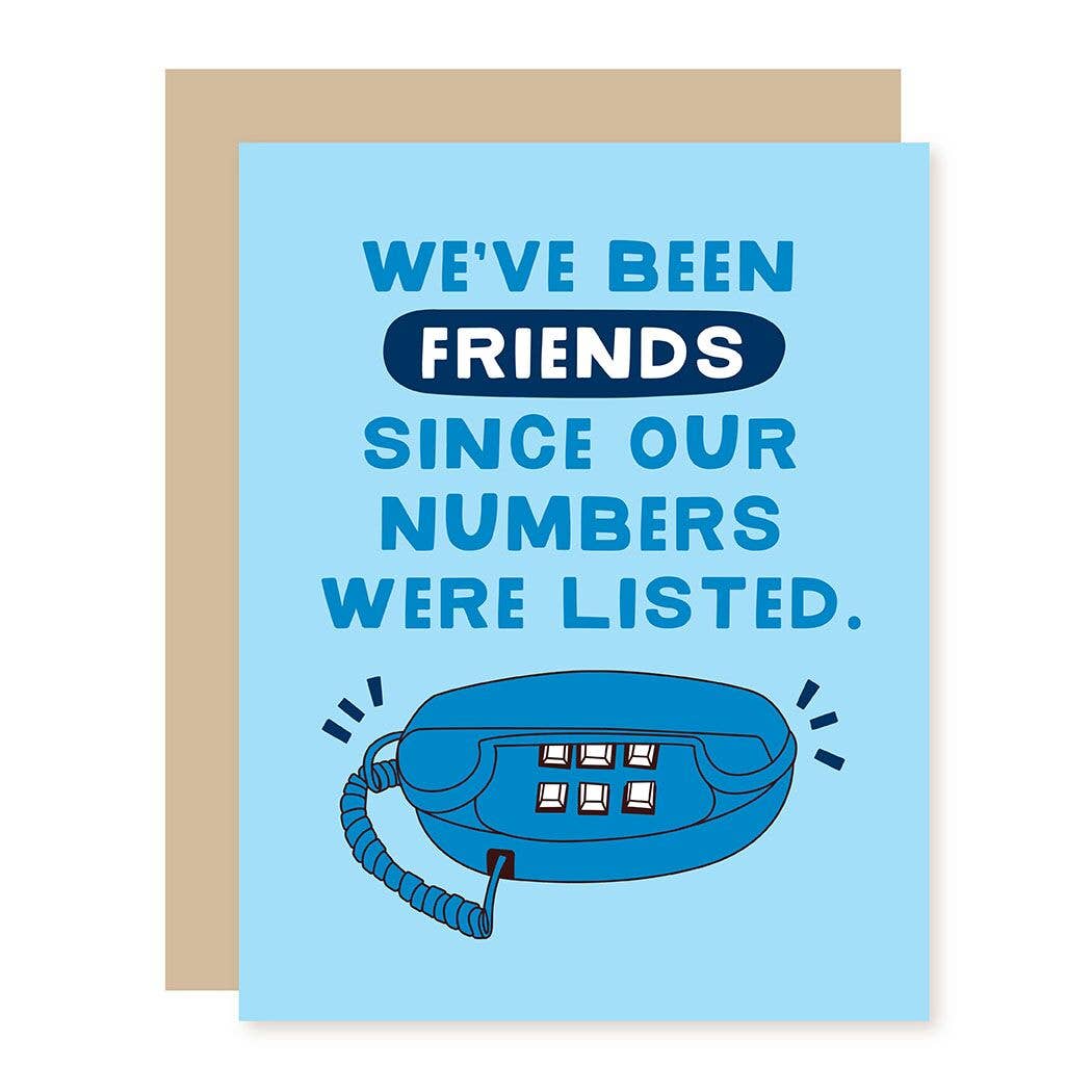 A light blue greeting card with a tan envelope behind it. The card features the text 'WE'VE BEEN FRIENDS SINCE OUR NUMBERS WERE LISTED.