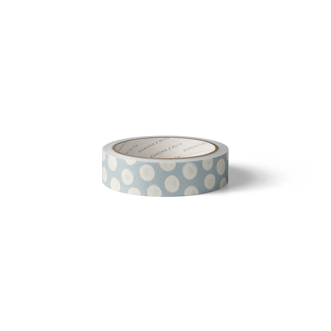 Side view of white dots on a roll of light blue washi tape.
