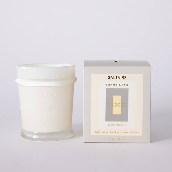 White glass jar sits beside its light gray packaging box. The box is labeled 'SALTAIRE' and features a central label with the brand name 'MERSEA' in gold.