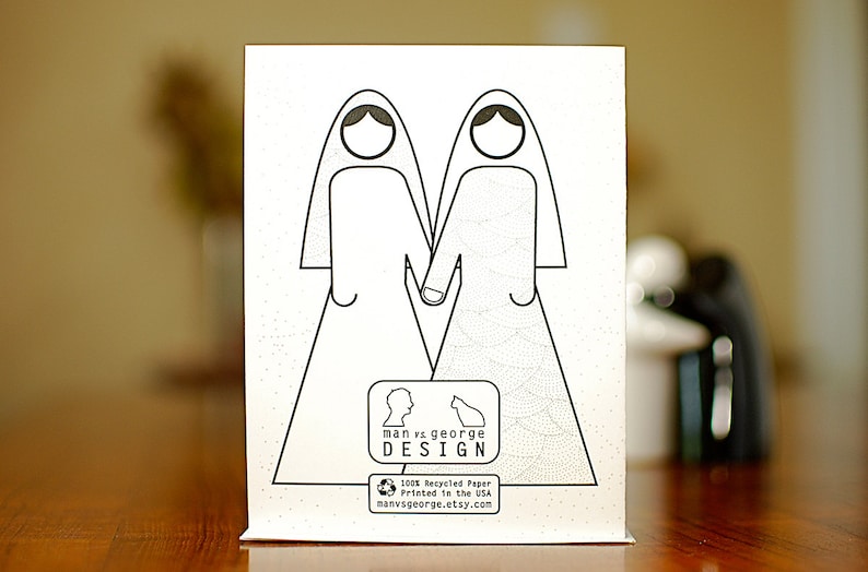 Greeting card back side with abstract drawing of two brides clasping hands and the log of man vs george design