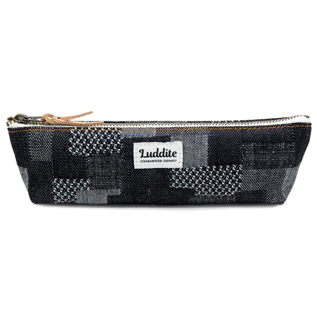 Black, gray, and white patchwork  pencil case with visible brand tag and top silver zipper.