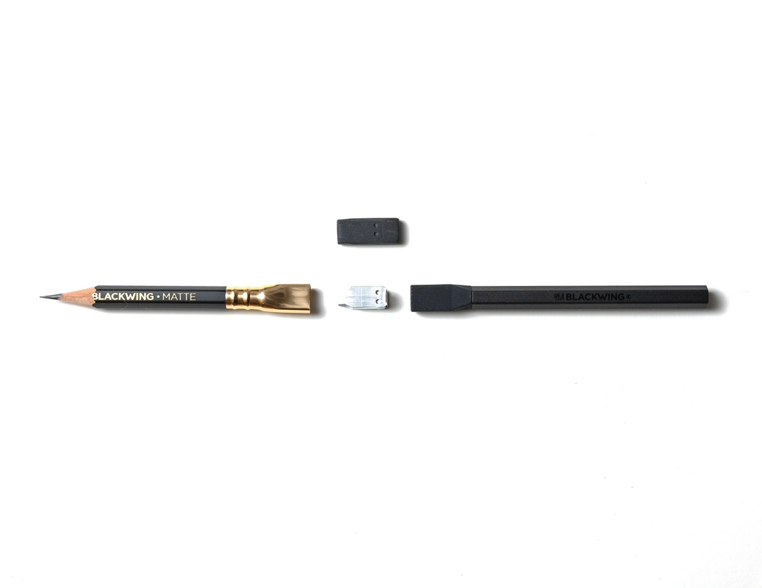 Blackwing pencil, extender, clip and eraser lined up horizontally and ready for assembly.