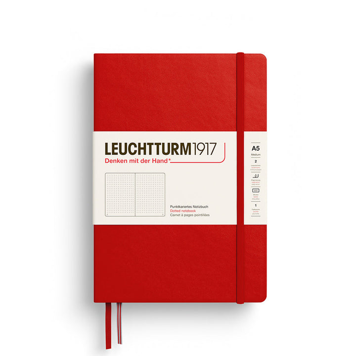 A Leuchtturm1917 A5 hardcover dotted page notebook in red with a white label on the front, shown closed with an elastic closure and ribbon bookmark. 