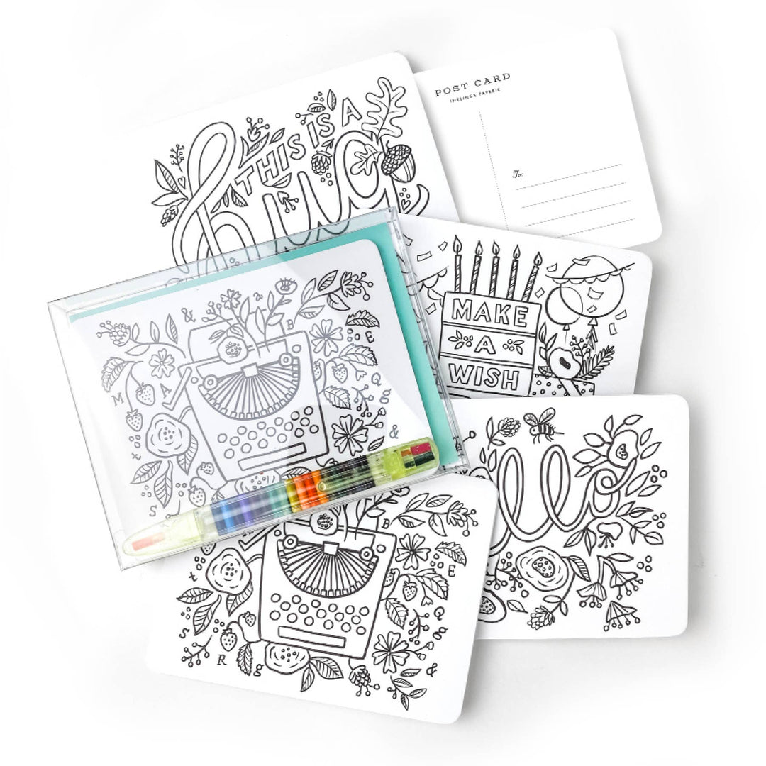 Pile of the front of the four color-in post card designs, with the pens, and one showing the back of the card.