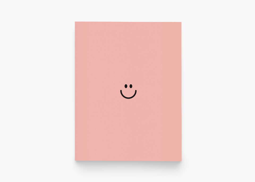 Pink cardstock with the eyes and mouth of a happy face in brown.