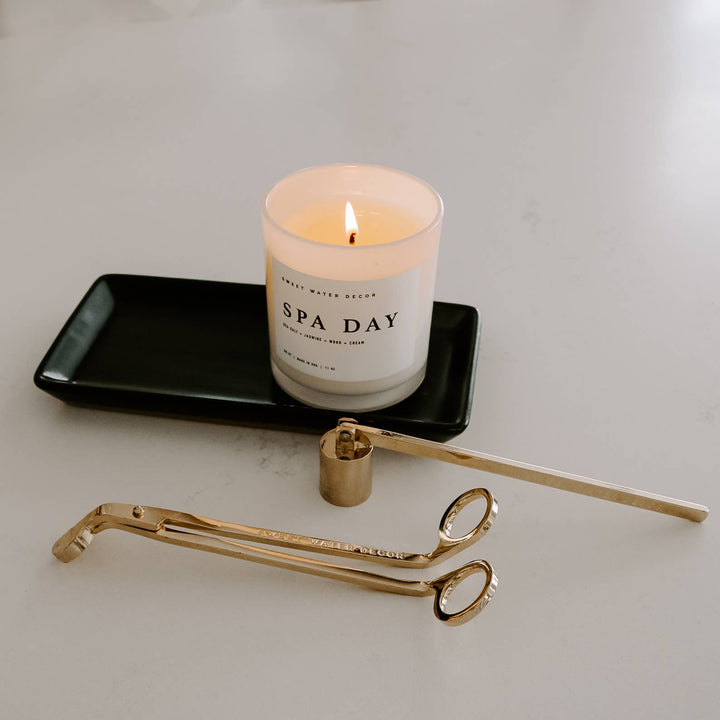 Black matte tray holding candle with candle tools.