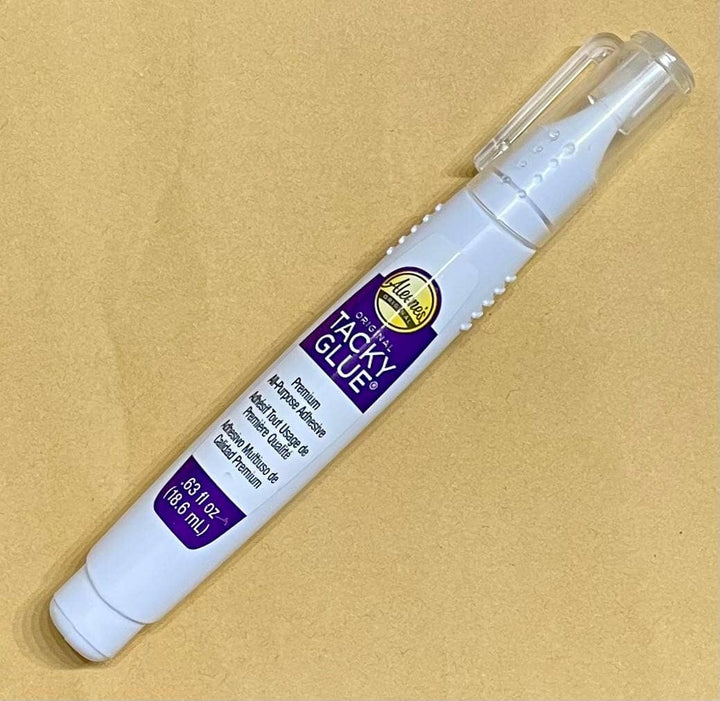 Pen-lie tube of tacky glue with removable cap.