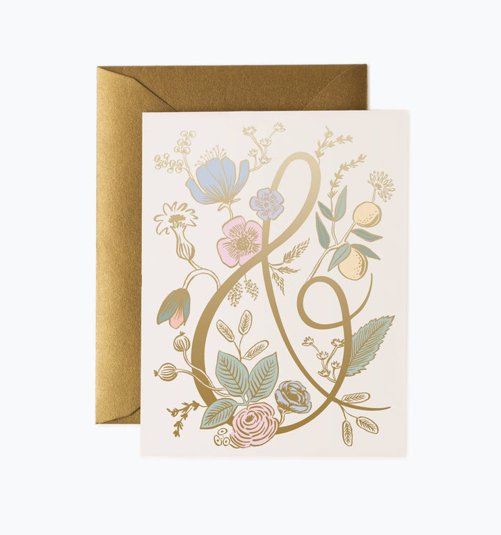 Greeting card with floral decorations and large gold ampersand and a gold envelope